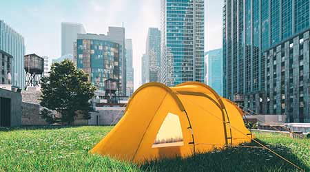 Yellow tent on grassy building roof surrounded by buildings.                                                                                          