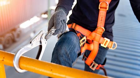 Construction worker uses safety harness and safety line at elevated height.                                                                           